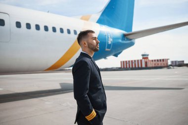 Uzağa bakan ciddi bir uçak kaptanı.