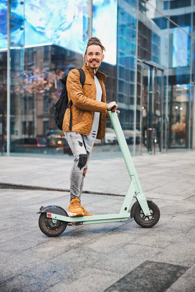 Zufriedener Mann reitet durch die Stadt und sieht glücklich aus — Stockfoto
