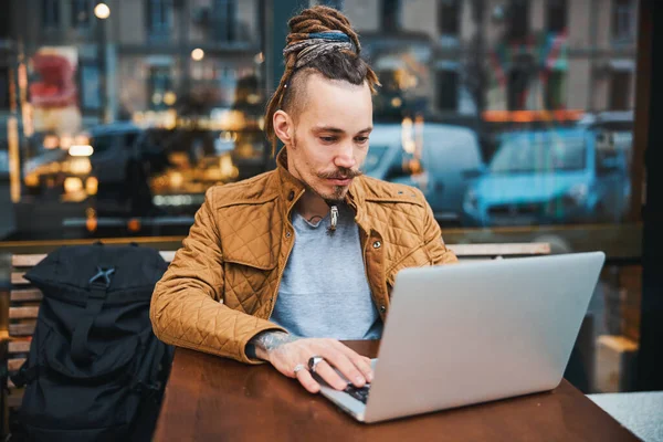 Серйозний концентрований чоловік працює на ноутбуці на відкритому повітрі — стокове фото