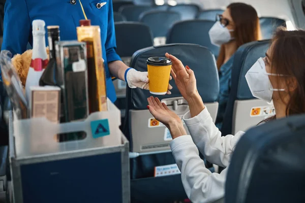 Flygvärdinna ger kaffekopp till tacksamma passagerare — Stockfoto