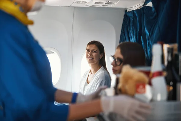 Livlig kvinna stirrar på passerande flygvärdinna med vagn — Stockfoto