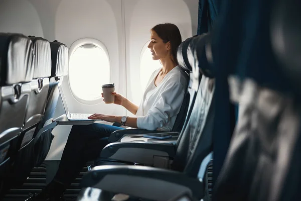 Passeggero donna godendo il suo caffè durante il volo — Foto Stock