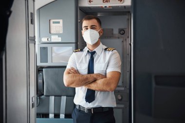 Beyaz gömlekli ve mavi kravatlı yakışıklı pilot tek başına duruyor.