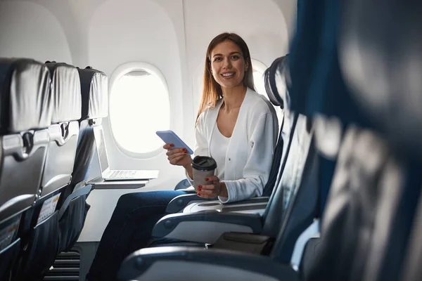Nöjd kvinnlig passagerare i flygplanet sittande ensam — Stockfoto