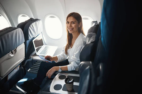 Feliz dama en el avión con dispositivos modernos — Foto de Stock