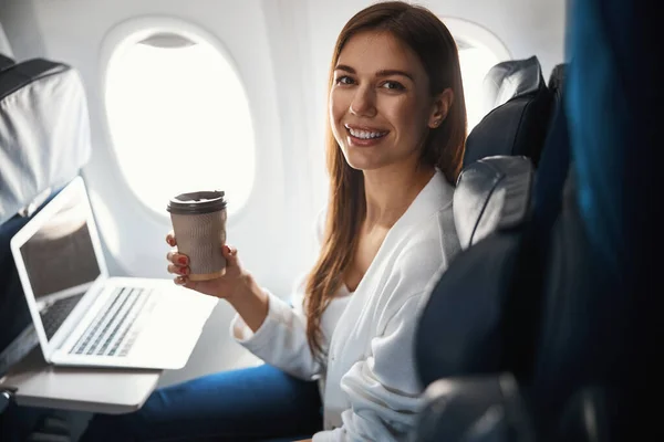 Női utas kedvenc forró italával repülés közben — Stock Fotó
