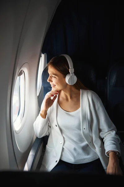 Contented lady looking at the clouds during the flight — Stock Photo, Image