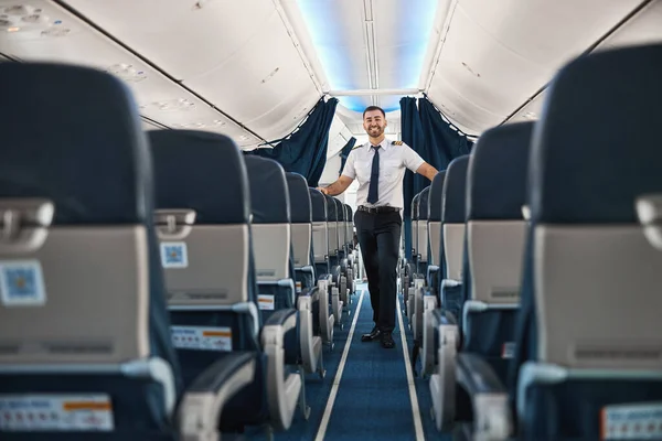 Vänlig vit pilot inbjuder passagerare till planet — Stockfoto
