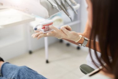 Avuç içinin üzerinde duran diş modelleri.