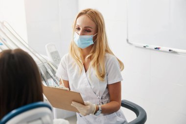 Müşteriye dik dik bakarken kadın doktor yazma notları almak