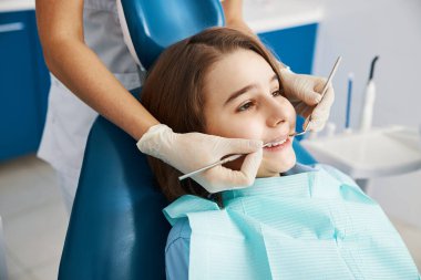 Sonda ve ağız aynası olan çocuğun diş muayenesi