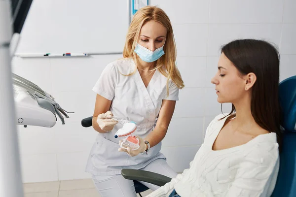 Donna in scrub pulizia denti lato modello con spazzolino da denti — Foto Stock