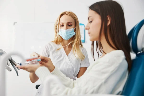 Geconcentreerde vrouw schoonmaken van tanden indruk met tandenborstel — Stockfoto