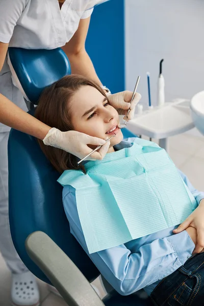 Bange teenager i tandklinik under tandlægeundersøgelse - Stock-foto