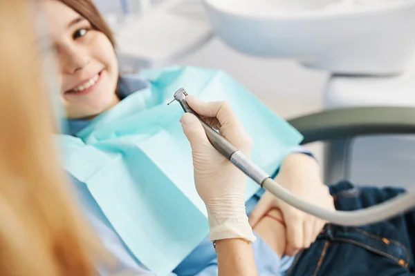 Handpiece in hand of dental practitioner over underage patient — Stock Photo, Image