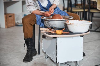 Çanak çömlek tasarımcısı tabaktan elektrik çarkıfeleğini çıkarıyor.