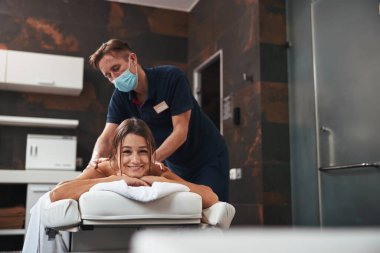 Çekici, pozitif, rahat kadın spa salonunda gerekli yağ ile aroma terapisinin tadını çıkarıyor.