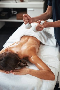 Tanınmayan erkek masör tıp merkezinde geleneksel olmayan bir masaj yapıyor.