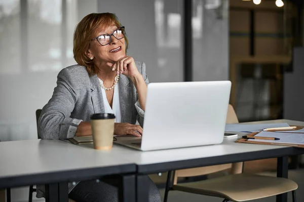 Fröhliche Geschäftsfrau lächelt auf Laptop-Bildschirm während Besprechung — Stockfoto