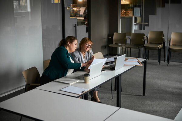 Сотрудница привлекает внимание директора к бумаге