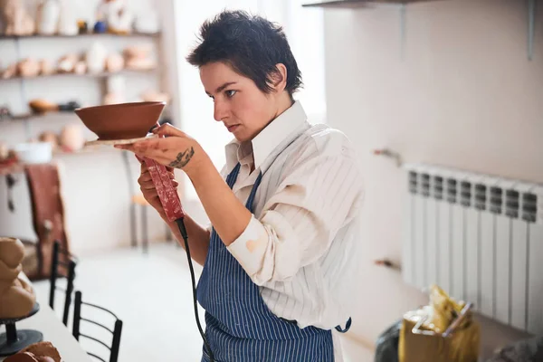 Женщина-гончар с помощью ручного экструдера на глиняной чаше — стоковое фото