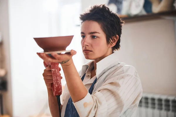 Fabricante de olla mujer extrusora operante mientras trabaja con plato de arcilla —  Fotos de Stock