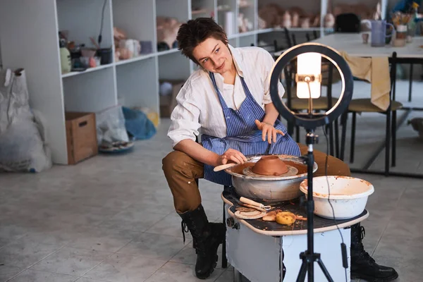 Töpferkopf kippen und beim Töpfern in die Kamera schauen — Stockfoto