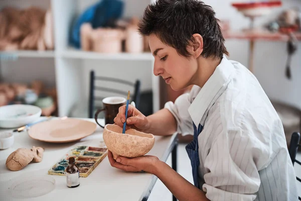 Мирный гончарный дизайнер, работающий над живописью в глиняной чаше — стоковое фото
