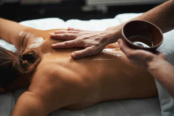 Gericht beeld van vrouwelijke liggend op massage bed tijdens het ontvangen van aroma behandeling in wellness centrum — Stockfoto