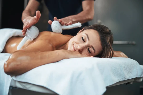Mooie schattige vrouw genieten van niet traditionele massage in wellness centrum — Stockfoto