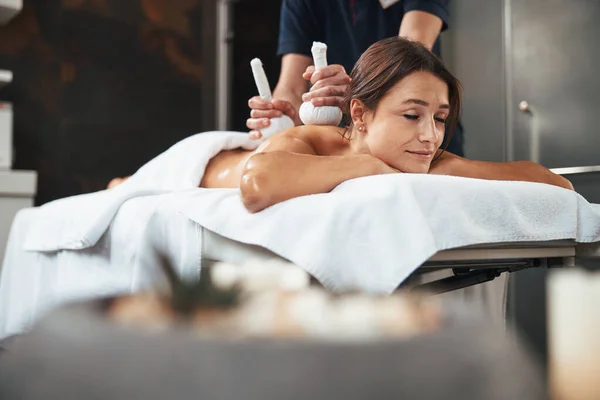 La mujer alegre feliz pacífica que recibe el masaje no tradicional en el salón de spa — Foto de Stock