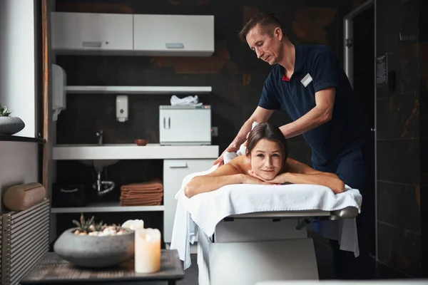 Erwachsene kaukasische männliche Masseur in blauer Uniform Heilung Körperbehandlung im Wellness-Spa-Salon — Stockfoto