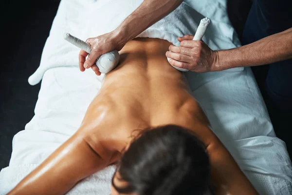 Onherkende mooie vrouw liggend op massagetafel en het ontvangen van professionele spa behandeling in harmonie beauty center — Stockfoto