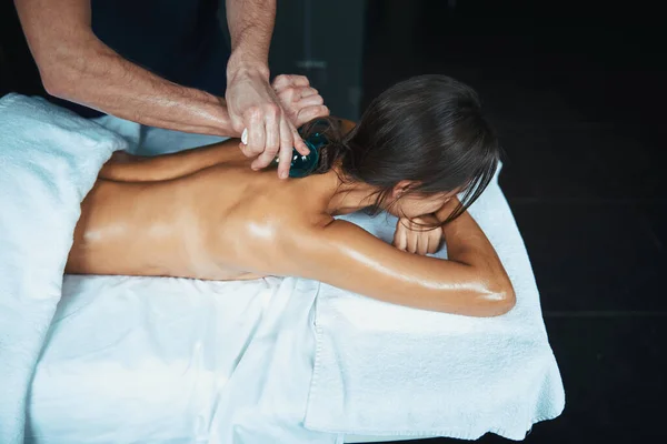 Affascinante elegante femmina sotto l'asciugamano rilassante presso la nuova tecnica di massaggio nel salone spa — Foto Stock