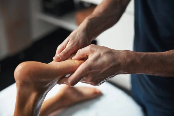 Krásná půvabná žena nohy v mužských masér ruce dostat manuální terapii s esenciálním olejem v lázeňském salonu — Stock fotografie