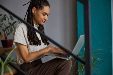 Dizüstü bilgisayarı üzerinde çalışan konsantre çiçek tasarımcısı.