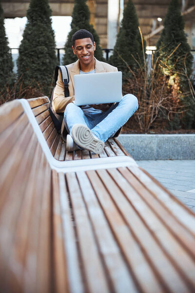 Добрый молодой человек, отдыхающий на скамейке