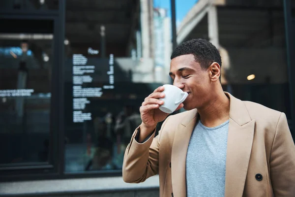 Jonge ontspannen freelance medewerker die buiten koffie drinkt — Stockfoto