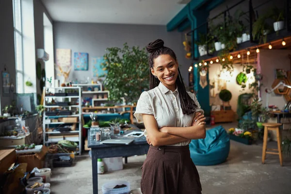 Pretty florist with cornrows looking in front of her — Stock fotografie