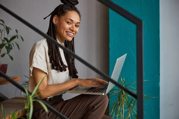 Jovem agradável usando seu laptop no trabalho — Fotografia de Stock