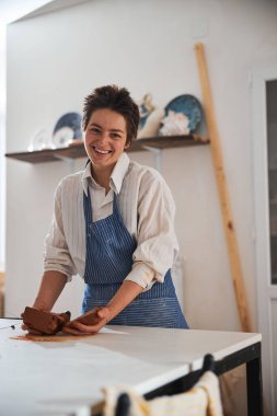 Positive delighted potter looking straight at camera
