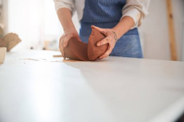 Focused photo on hands holding pieces of fireclay