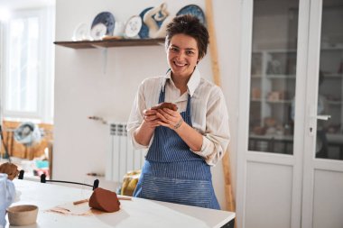 Kamerada poz veren esmer kadın.