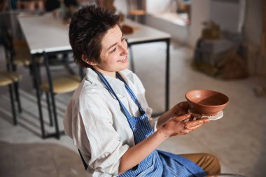 Positive delighted master spending her day in workshop