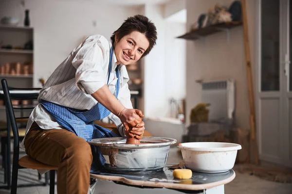 Positief verheugd vrouwelijke persoon gieten klei vaas — Stockfoto