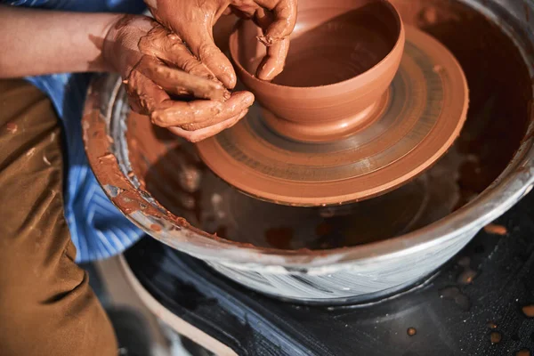 Professional ceramist shaping clay pot on special wheel — Photo