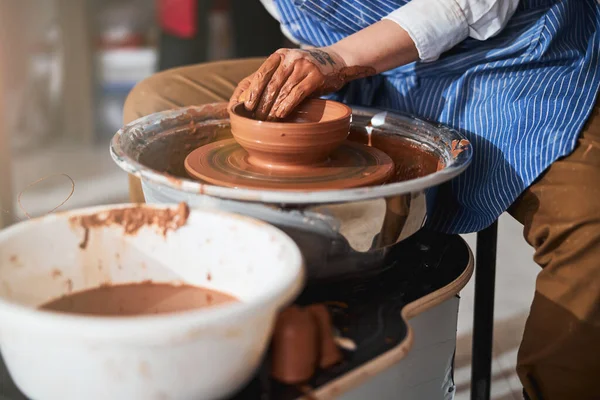 Młody mistrz tworzący gliniane naczynia na kołowrotku — Zdjęcie stockowe
