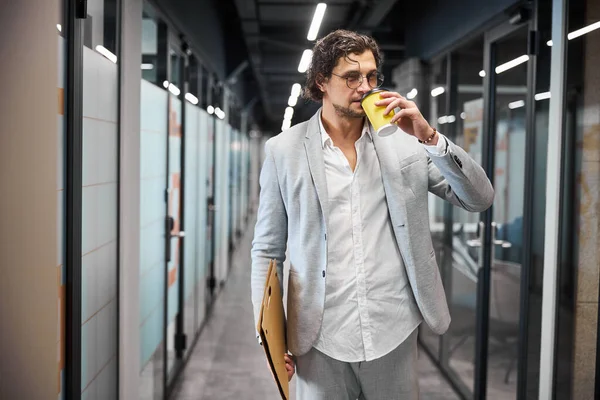 Handsome male person drinking aroma coffee in office — Stock Photo, Image