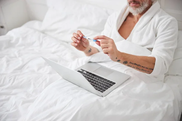 Barbă de sex masculin petrecerea timpului pe dormitor la laptop — Fotografie, imagine de stoc