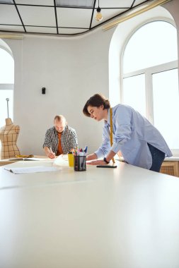 Productive fashion designer is examining the drawings
